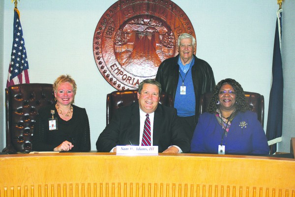 In recognition of National Family Caregivers Month, Emporia Mayor Sam Adams, center, signs a City proclamation recognizing caregivers and the hundreds of individuals who work daily caring for members of the community.